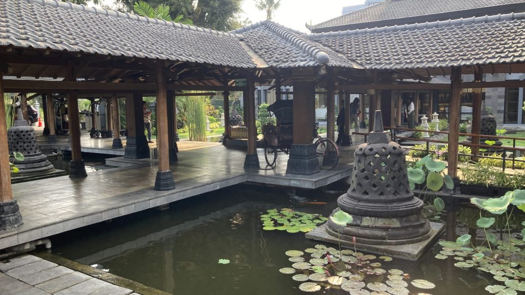 建在水池上的木造走廊，池中有佛塔造型石雕與睡蓮
