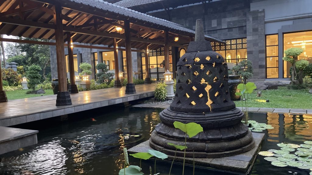 傍晚點燈的水池走廊，池中佛塔造型石雕透出燈光